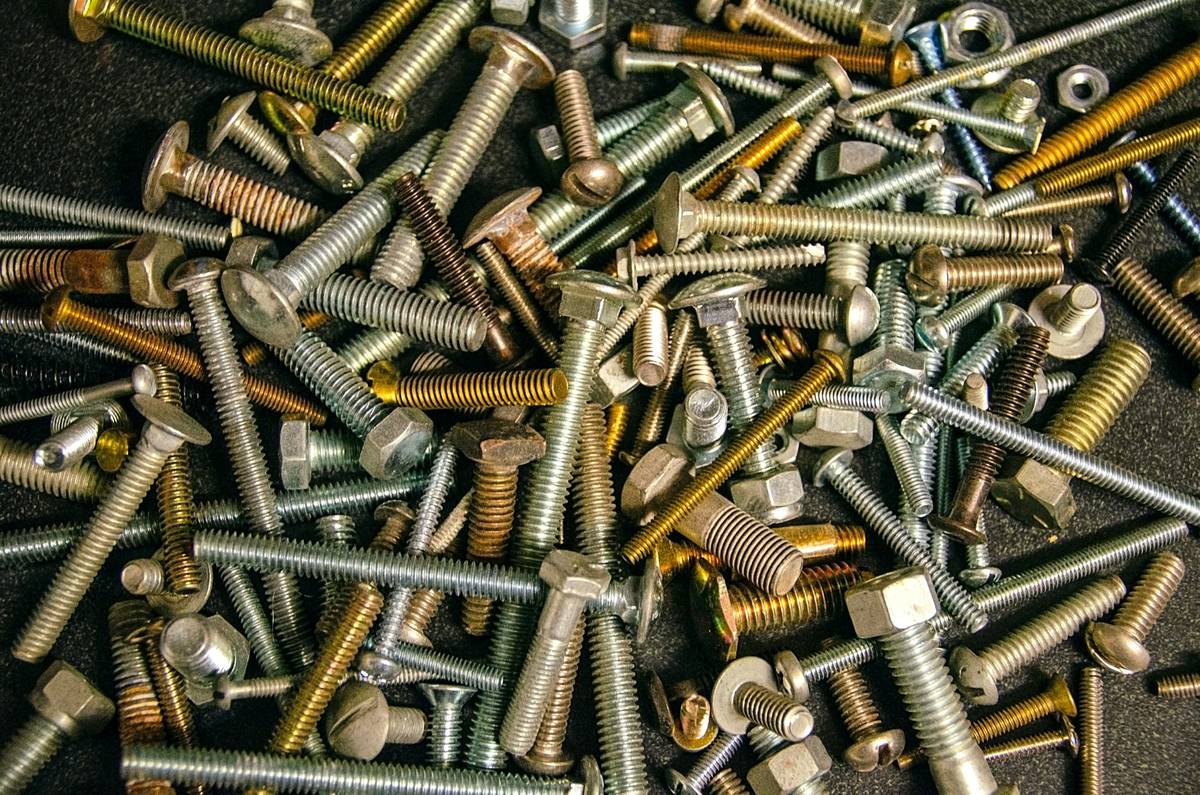 Assorted machine screws sizes displayed on a ruler showing diameter and length measurements